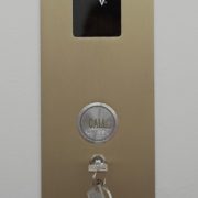 Hall Call Station with display read out and security key switch in brushed brass metal finish